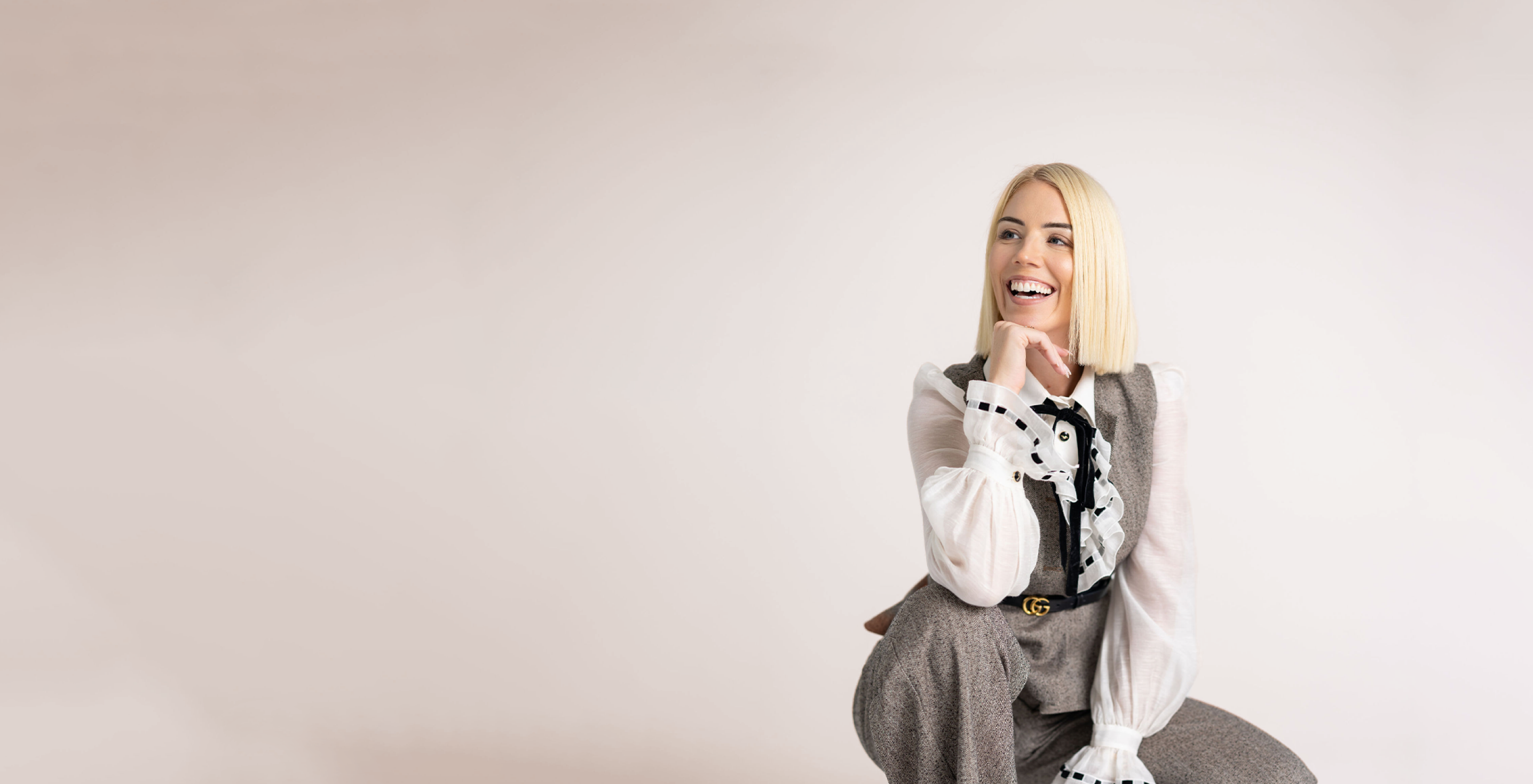 Jessica Gwynne seated in a cream-toned studio.